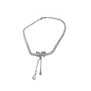 Elegant silver bow necklace with zircon stones and a hanging white pearl tassel