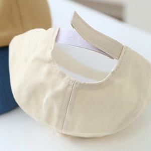 Detailed view of the adjustable velcro strap and premium stitching on a beige cotton cap