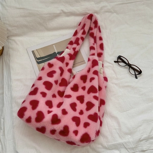 Detail shot of the plush pink faux fur fabric with heart patterns and soft texture