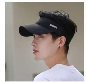 Close-up of black sports visor with purple SPORTS label on breathable polyester fabric