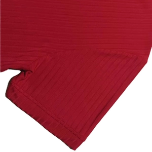 Detail shot of red ribbed knit fabric showing fine texture and sewing workmanship