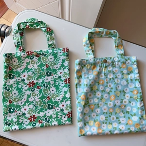 Detailed view of floral cotton tote bags with bronze button closures and top handles