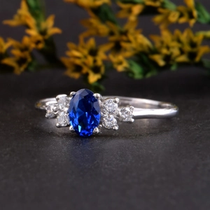 Detail van een ovale saffierblauwe edelsteen ring met zirkonia op een stenen vlak