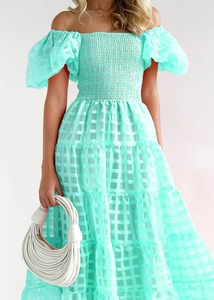 Detail of mint green off-shoulder dress featuring plaid textured organza and tiered skirt