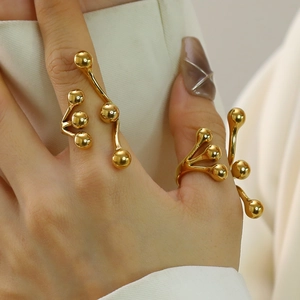 Detailed view of polished 18k gold-plated stainless steel bead rings on a model hand