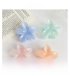 Macro detail of candy-colored plumeria flower hair clips in translucent pastel resin