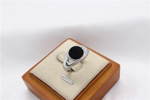 Detail of round black agate signet ring in polished silver finish on display stand