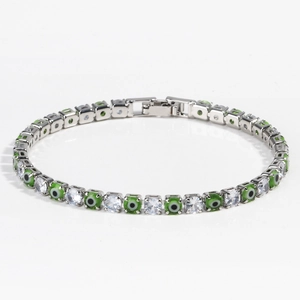 Detail of silver tennis bracelet with green evil eye charms and white zircon stones