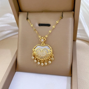 Detailed macro of golden tassel lock necklace with diamonds and white inlay on silk