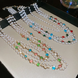 Collier de perles multicouche vintage avec pierres précieuses sur plateau en cuir gris