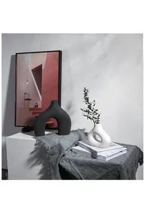 Detail van moderne Scandinavische keramische vazen in matzwart U-vorm en wit ringontwerp