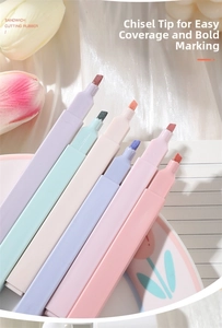 Close-up of 6-color macaron chisel tip highlighters fan-shaped on notebook with tulips