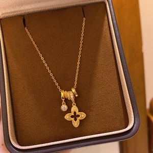 Détail du collier à pendentif fleur plaqué or 18 carats avec cristal dans un écrin brun