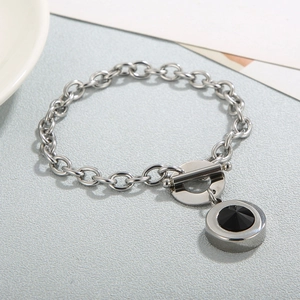Macro detail of silver OT buckle chunky chain bracelet with a faceted black stone pendant