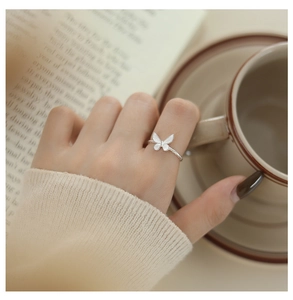 Exquisite butterfly ring in silver finish displayed on a coffee table with soft lighting