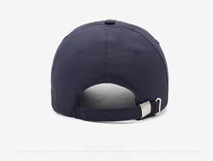 Detail of navy quick-dry baseball cap featuring an adjustable metal buckle and back strap