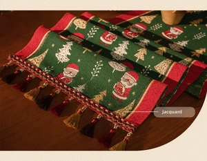 Detailed macro view of green Christmas table runner with festive jacquard and tassels