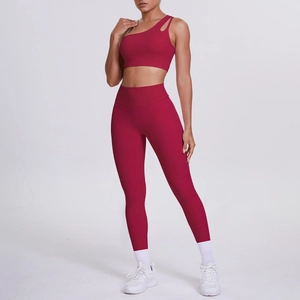 Detail of red one-shoulder sports bra and high-waist leggings on a fitness model