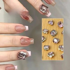 Macro view of 12-grid nail sequins featuring dried rose pink gems, pearls and heart shapes