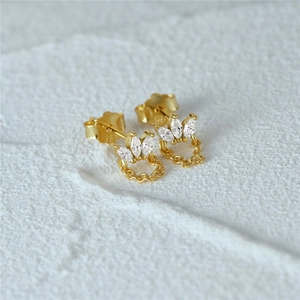 Detail of s925 silver gold-plated stud earring with marquise cubic zirconia crown and chain