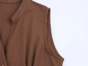 Detail of dark brown linen-like fabric and stitching on sleeveless V-neck dress
