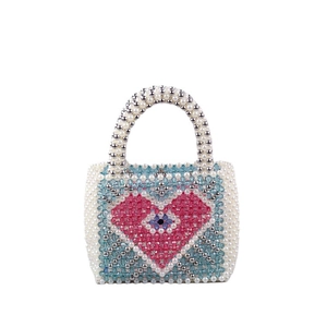 Handmade beaded handbag with pink heart and evil eye detail on white background