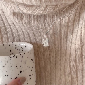 925 Sterling silver necklace with irregular geometric pendant shown on beige sweater