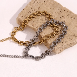 Macro view of chunky 14K gold and silver chain link anklets with lobster clasps