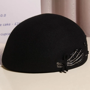 Detail of wool beret featuring black bow with crystal rhinestone leaf embroidery