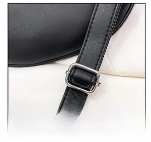 Detail showing high-quality black leather shoulder strap with silver metal buckle