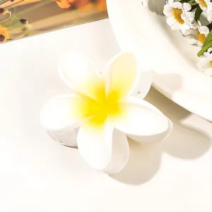 Detailed view of frangipani flower hair claw with matte white petals and yellow center