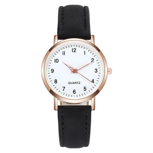 Detail of rose gold quartz watch with white dial and black leather strap for women