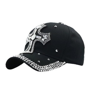 Macro detail of sparkly rhinestone cross design on black cotton baseball cap