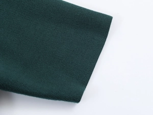 Detailed view of dark green knit sweater cuff showing fine texture and stitching