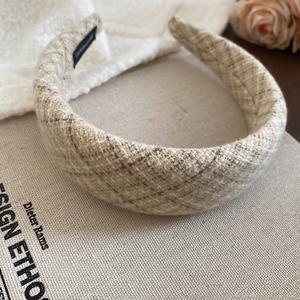 Dettaglio del cerchietto spesso in tweed scozzese beige con etichetta fatta a mano