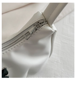 Detail of white PU crescent bag showing silver zipper and black butterfly metal charm