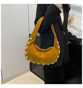 Dettaglio della borsa hobo in pelle scamosciata giallo senape con borchie argento