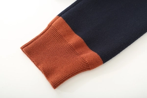 Close-up of navy and caramel color-block knit sweater with ribbed cuffs detail