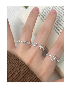Close-up of S925 sterling silver flower rings with hollow petals and vine texture