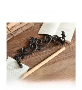 Detail of vintage cast iron tissue holder with European scroll carving and wood rod
