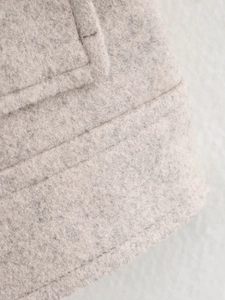 Nahaufnahme der hellgrauen Tweed-Stoffstruktur und der robusten Doppelnaht-Details