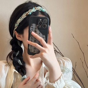 Detail of light green silk headband woven with silver chains and beads on a braided hairstyle