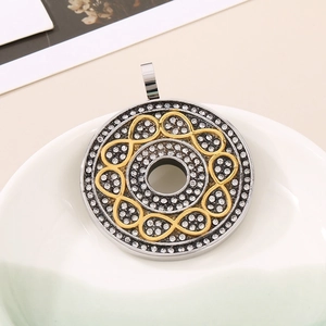 Detailed view of a round infinity pendant with sparkling rhinestones in a white dish