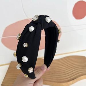 Detail of black fabric headband featuring faux pearls and sparkling rhinestones