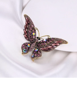 Vue détaillée d'une broche papillon en strass violets sur tissu en soie blanche
