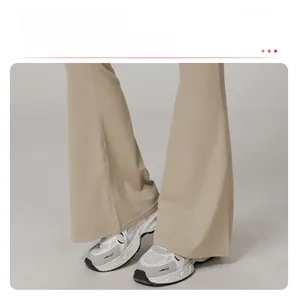 Detail view of beige high-waisted flare yoga pants with elegant draped bottom cuff hem