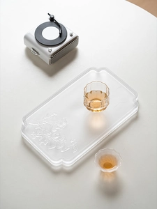Detail of square glass tea tray with embossed birds and flowers, minimalist oriental style