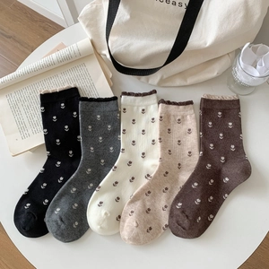 Vue à plat de chaussettes tulipes vintage avec bords ondulés en cinq couleurs