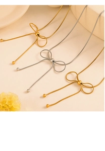 Detailed macro view of gold and silver snake chain necklaces with butterfly knot design