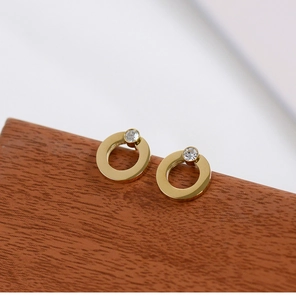 Close-up of geometric 18K gold plated circle earrings with a round sparkling diamond stud